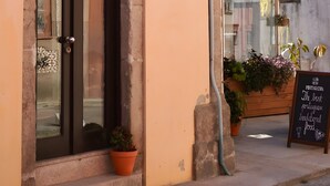 A building with a dark door, numbered 128, and a signboard advertising traditional Portuguese food. - Casa de São Roque 1 – Beachfront Apartment for 6 Guests (Vila do Conde)