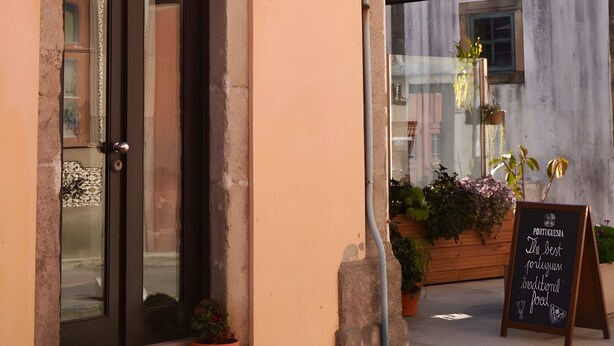 Un edificio con una puerta numerada, una farola y un letrero.