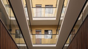 A multi-level atrium with a reception area, glass railings, and a tiled floor.