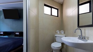 A compact bathroom with a toilet, sink, and a small window.