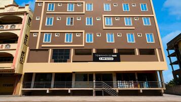 A multi-story building with a sign indicating it is serviced by OYO.