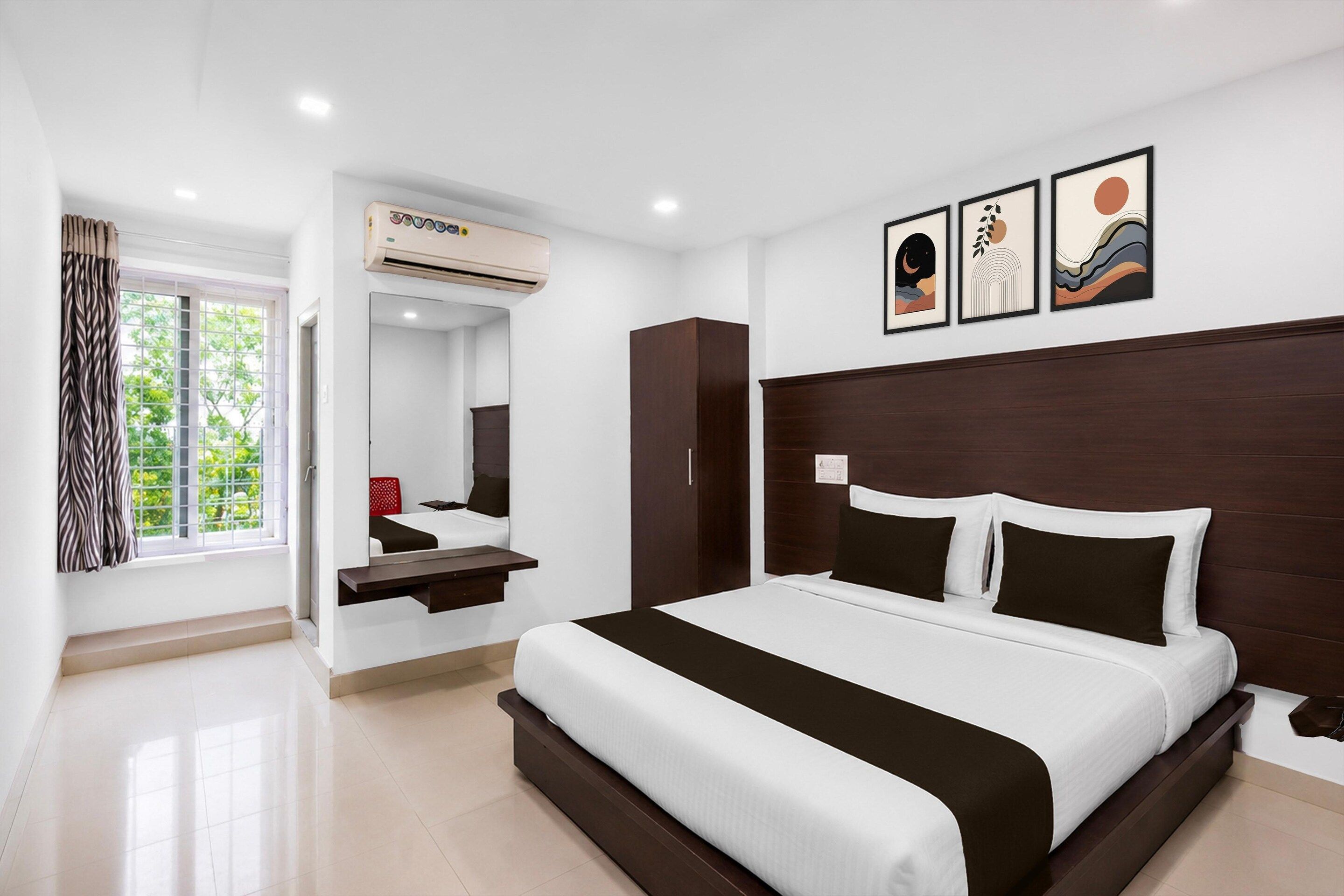 A modern hotel room with a large bed, a built-in wardrobe, a mirror, and a window with curtains.