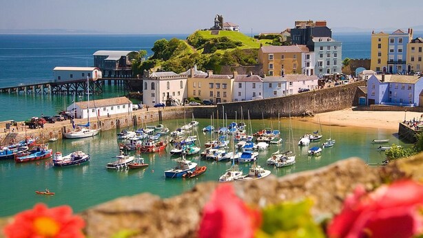 A coastal town with a harbor filled with boats, a lighthouse, and historic buildings. - 1 Bed in Tenby (oc-fb125) (Tenby)