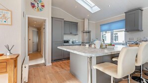A modern kitchen with a central island, grey cabinets, and a skylight. - 3 Bed in Stepaside (oc-fb132) (Stepaside)