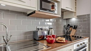 Eine moderne Küche mit Mikrowelle, Toaster, Spüle und Edelstahlgeräten.