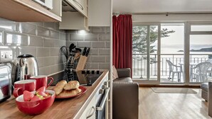 Eine moderne Küche mit Meerblick, ein Essbereich mit Ausblick und ein Balkon mit Sitzgelegenheiten.