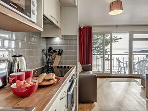 Eine moderne Küche mit Meerblick, ein Essbereich mit Ausblick und ein Balkon mit Sitzgelegenheiten.