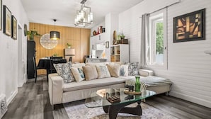 Una sala de estar moderna con sofá, mesa de centro y comedor.