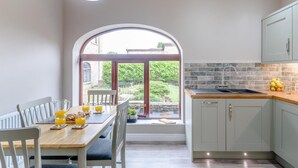 Eine Küche mit Essbereich, einem großen Fenster und Blick auf den Garten.