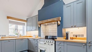 A modern kitchen with grey cabinets, a white oven, and a wooden countertop. - 1 Bed in Taunton (oc-80693) (North Curry)