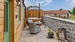 A patio with a hot tub, wicker furniture, and a barbecue grill. - 1 Bed in Taunton (oc-80693) (North Curry)