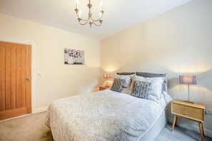 A bedroom with a bed, a wooden door, a wall-mounted picture, bedside lamps, and a nightstand. - 2 Bed in Toft Hill (oc-80004) (High Etherley)