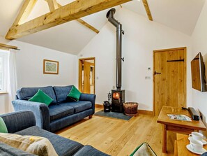 A cozy living room with a sofa, a table with cups, and a wood-burning stove. - 2 Bed in Taunton (oc-80694) (North Curry)