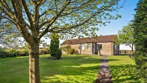 A stone house with a tiled roof, a well-maintained lawn, and a pathway leading to the entrance. - 2 Bed in Toft Hill (oc-80005) (High Etherley)