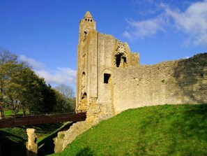 A historic stone structure with a tower, a bridge, and a grassy hill. - 1 Bed in Sherborne (oc-80737) (Middlemarsh)