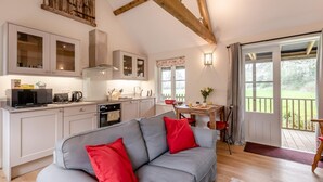 Eine moderne Küche mit weißen Schränken, einem eingebauten Backofen und einem Essbereich mit Tisch und Stühlen.