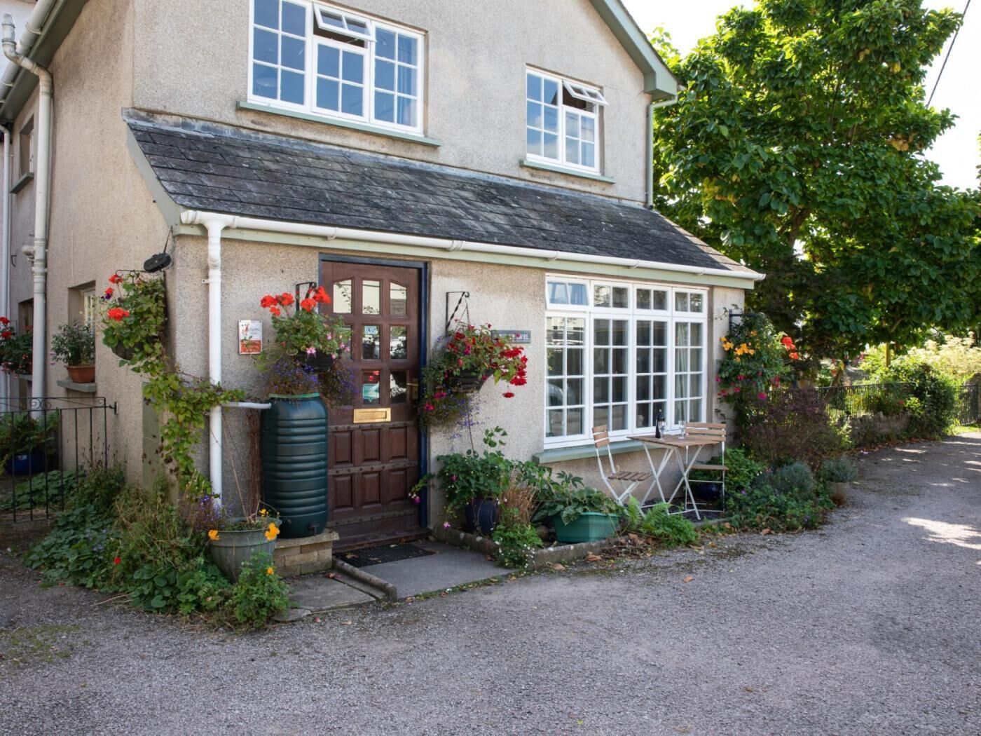 A traditional building with a front door, windows, and a small outdoor seating area.