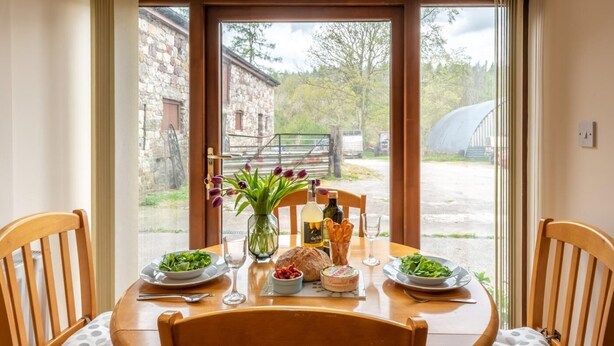 A dining table with chairs, a vase of flowers, and plates of food. - 1 Bed in Ystradgynlais (oc-bn046) (Ystradgynlais)