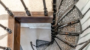 Eine Wendeltreppe mit aufwendiger Metallgeländerung und Holzrahmen.