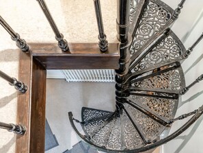 Eine Wendeltreppe mit aufwendiger Metallgeländerung und Holzrahmen.