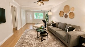 A living room with a sofa, coffee table, and a ceiling fan. - The Badlands Basecamp (Drumheller)