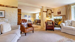 A spacious living room with a fireplace, a large window, and a stone wall. - 9 Bed in Brecon (oc-bn222) (Sennybridge)