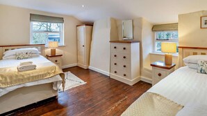 A bedroom with two beds, a dresser, a mirror, and a window. - 5 Bed in Cartmel (oc-80332) (Cartmel)