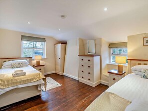 A bedroom with two beds, a dresser, a mirror, and a window. - 5 Bed in Cartmel (oc-80332) (Cartmel)