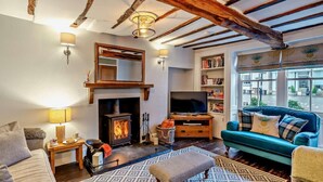 A cozy living room with a fireplace, a television, and a sofa. - 5 Bed in Cartmel (oc-80332) (Cartmel)