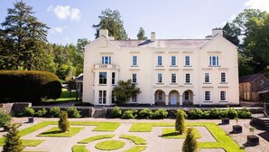 Ein großes, cremefarbenes Gebäude mit vielen Fenstern und einer symmetrischen Fassade.
