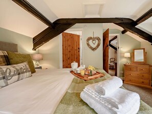 A bedroom with a bed, a dresser, a heart-shaped decoration, and a tray with breakfast items. - 2 Bed in Llandovery (oc-bn426) (Llandovery)