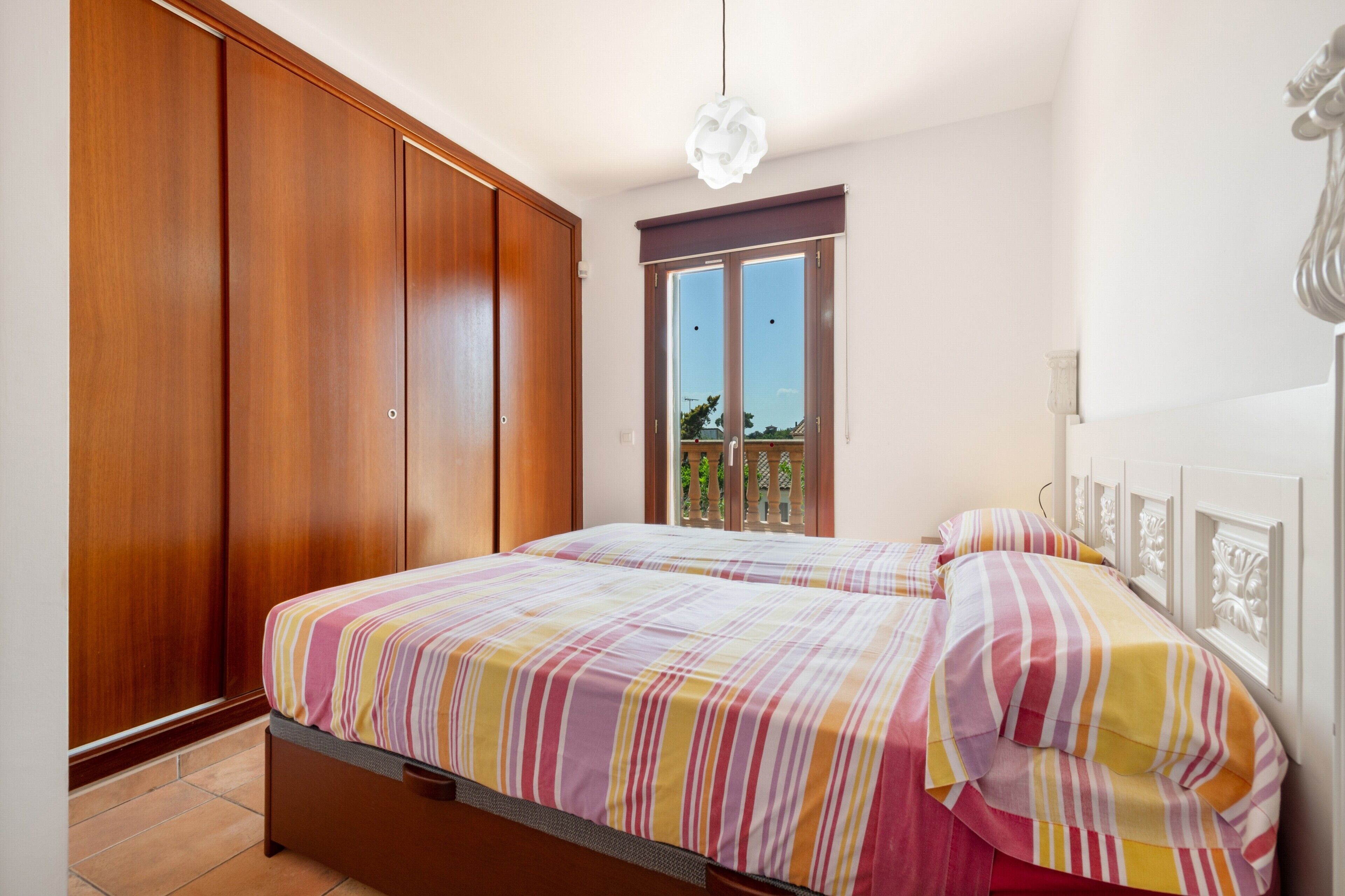 Ein Schlafzimmer mit einem Bett, einem Kleiderschrank und einem Fenster.