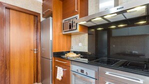 Uma cozinha com micro-ondas, forno e fogão.