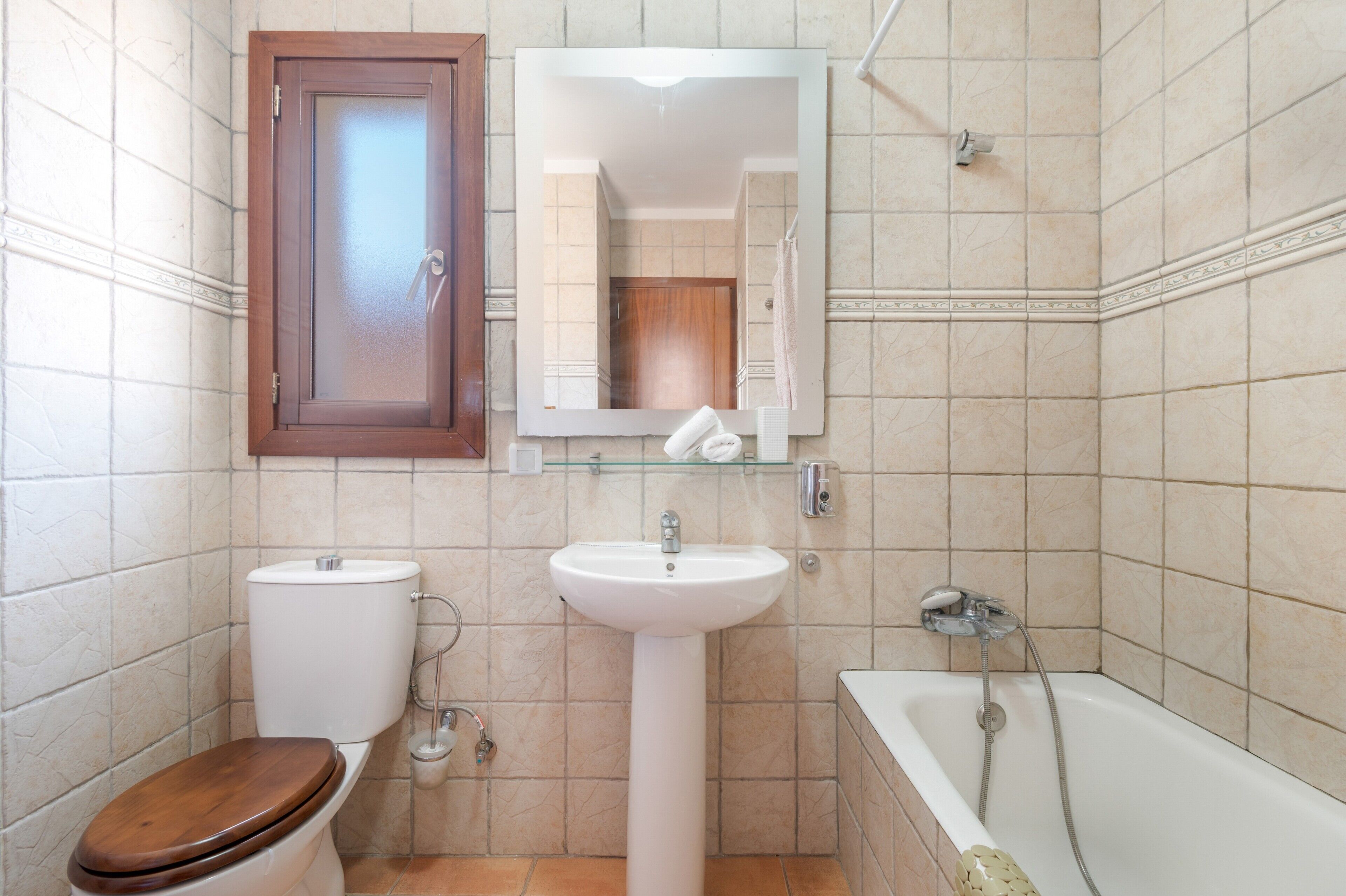 Een badkamer met toilet, wastafel en bad.