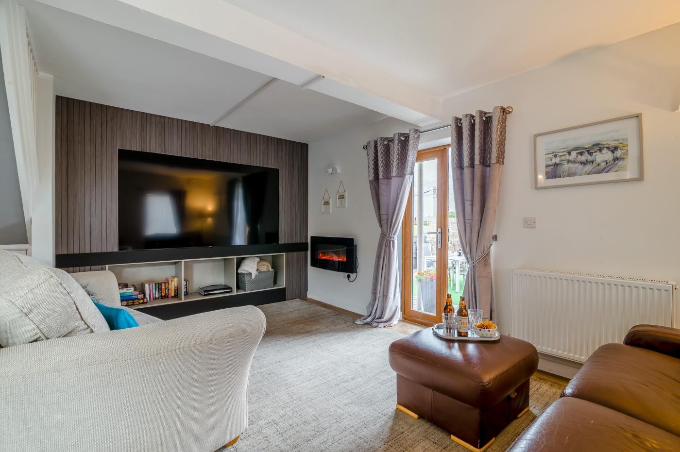 A living room with a flat-screen TV, a fireplace, a sofa, and a coffee table.