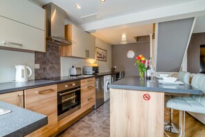 Eine moderne Küche mit Einbauofen, Mikrowelle und Kaffeemaschine.