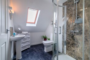 A modern bathroom with a skylight, a shower, and a toilet. - 1 Bed in Builth Wells (oc-bn274) (Builth Wells)