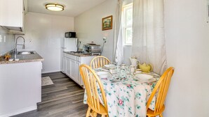 A compact kitchen with white cabinets, a microwave, a toaster, and a sink.