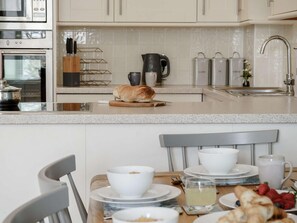 Forn, rentaplats, trona i utensilis de cuina, vaixella i coberteria 