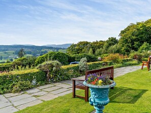 A garden with a bench, a decorative urn, and a stone pathway. - 3 Bed in Ambleside (oc-81068) (Claife)