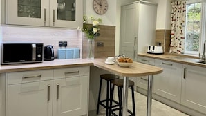 Eine moderne Küche mit Mikrowelle, Toaster und Barhocker.