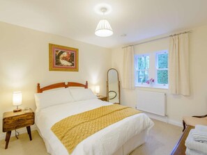 A bedroom with a bed, bedside lamps, a window with curtains, a radiator, and a framed picture on the wall. - 3 Bed in Buxton (oc-81127) (Buxton)