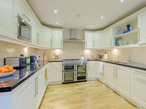 A modern kitchen with white cabinets, a gas stove, an oven, and a sink. - 3 Bed in Buxton (oc-81127) (Buxton)