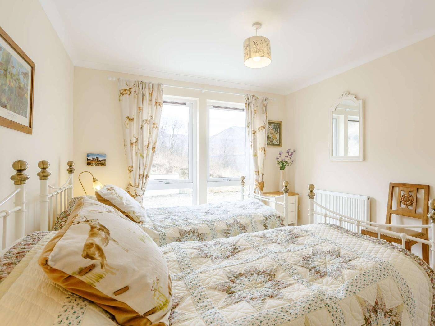 A bedroom with two beds, a window, a radiator, and a mirror.
