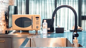A kitchen with a microwave, a water bottle, and a coffee maker on a countertop. - Private House Hibiki (Nara)