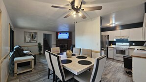 A modern kitchen with white cabinets, a built-in oven, and a stainless steel refrigerator.