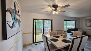 A dining area with a table, chairs, and a ceiling fan.