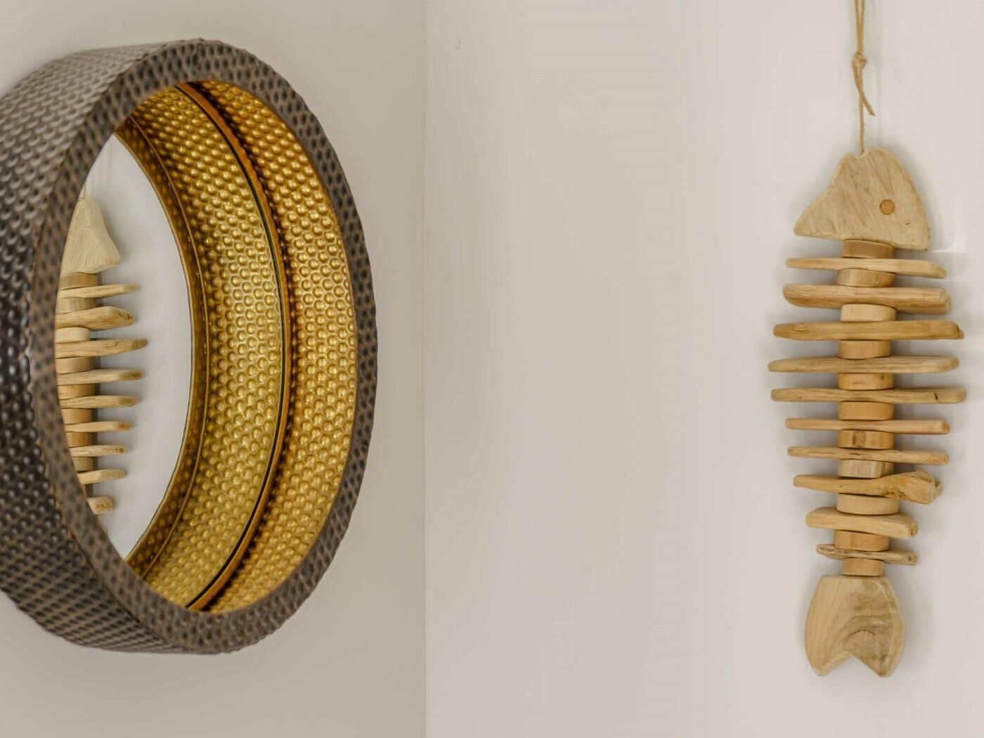 Un oggetto circolare con interno decorato e un ornamento a forma di pesce in legno da appendere.