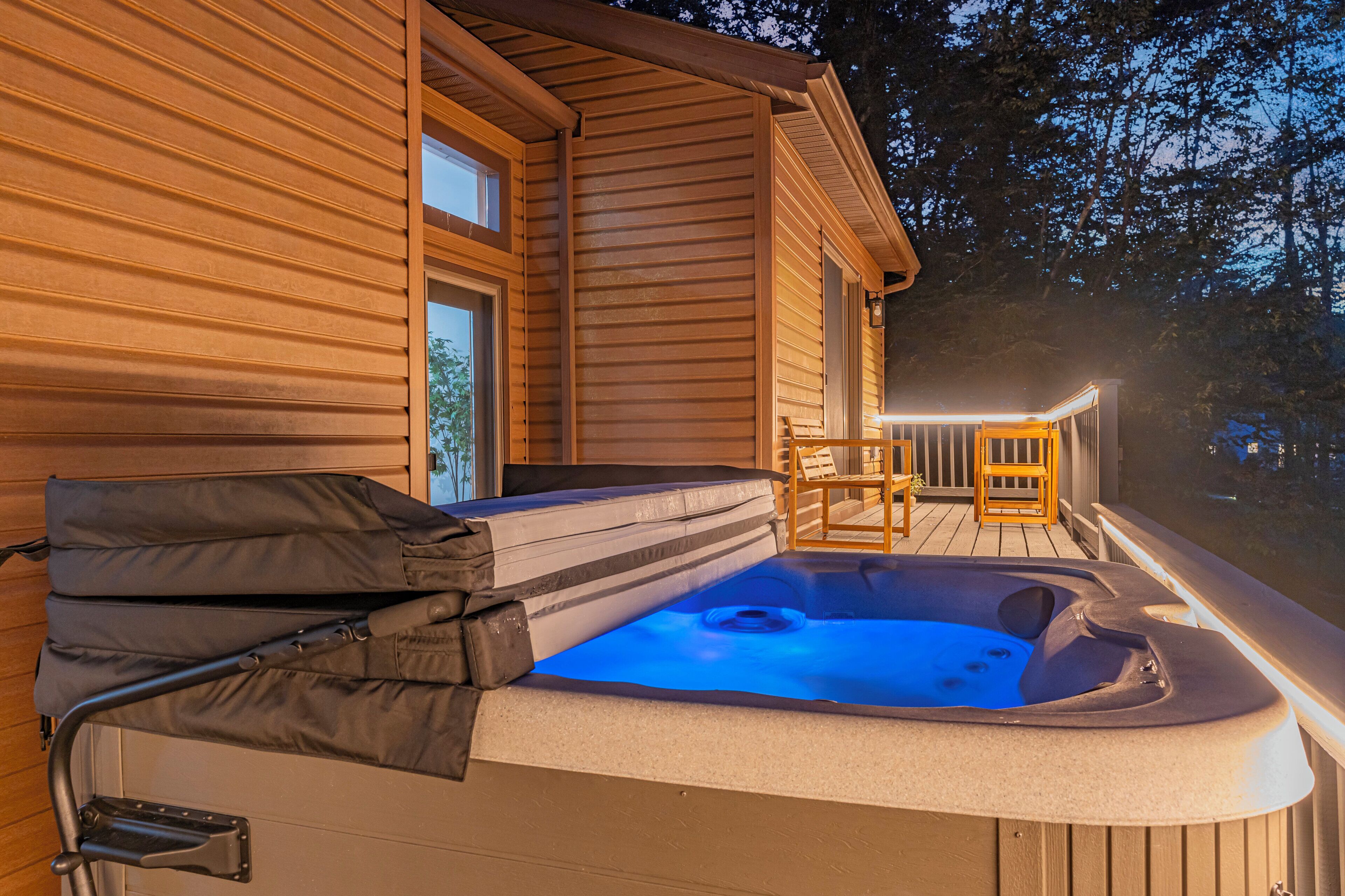 A wooden cabin with a hot tub and outdoor seating.