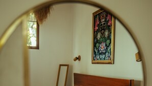 A bed with white bedding, a wooden headboard, and a framed floral artwork on the wall. - Samaya Lush Lakeside Apt - White Lotus (San Miguel)